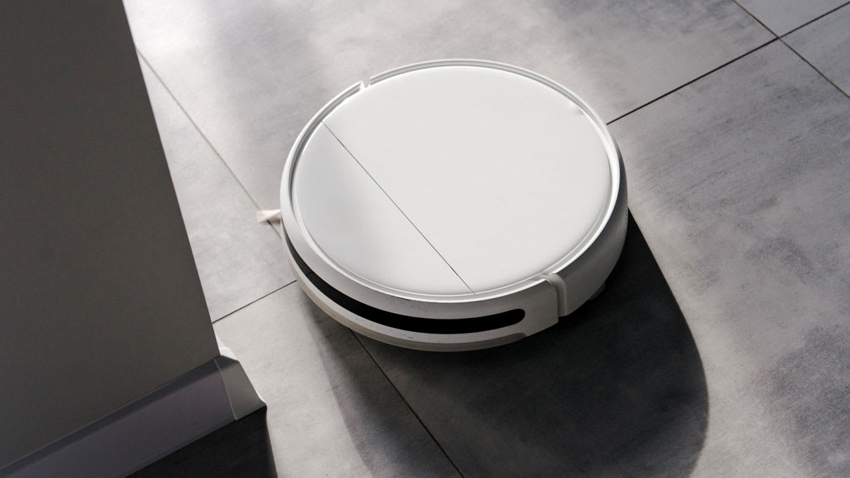 A robotic vacuum on a tiled floor.