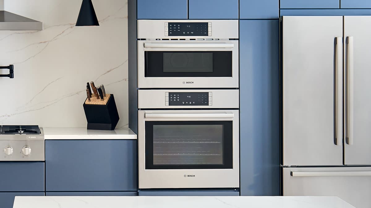 Bosch 800 Series HBL8753UC wall oven microwave combo in kitchen with blue cabinets