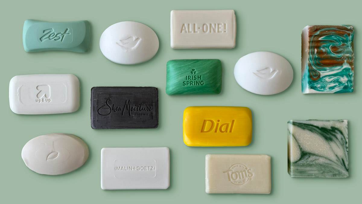 grid of 13 different types of bars of soap on light green background