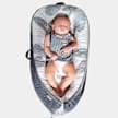 A baby asleep on their back in a Mumzworld Little Story Soft Breathable Newborn Lounger Bed.
