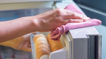 Person wipe top of refrigerator door