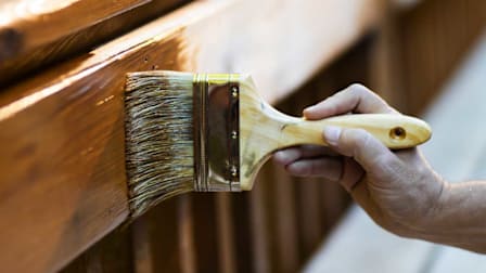 Hand brushing stain onto wood