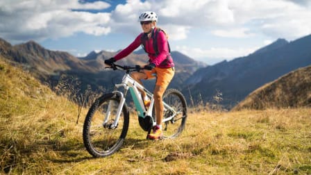 Woman with helmet on ebike mountain biking