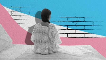 A Transgender Woman sits in a hospital gown on a hospital bed. In front of her is an illustration of a brick wall with the color of the Transgender flag.