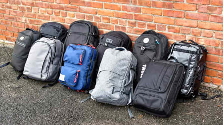 10 Backpacks against a brick wall