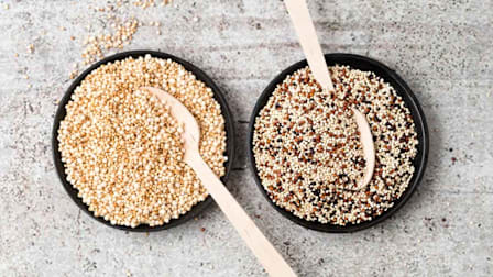Wholemeal quinoa and popped quinoa in bowls with wooden spoons