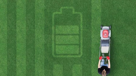 Stripes and battery icon mowed into lawn with a person and mower