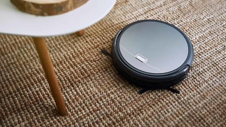 A robot vacuum seen on a carpeted floor.