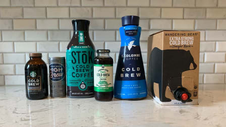 A number of cold brew coffee products sitting on a kitchen counter.