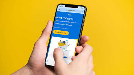 Person holding phone with screen grab of  Walmart+ signup page