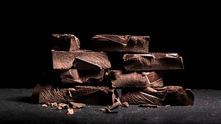 Stacks of dark chocolate on a black background