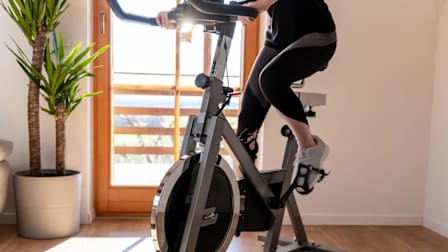 detail of bottom half of person on exercise bike in room of house