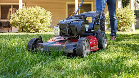 Person pushing the Toro 21311 lawn mower on a lawn.