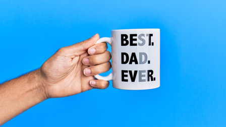 hand holding a Best Dad Ever mug