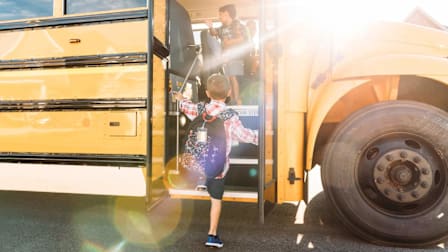 kid getting onto school bus with kid and driver already on bus