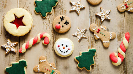 Variety of holiday cookies on wooden table.