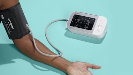 close up of person's arm with Omron blood pressure monitor