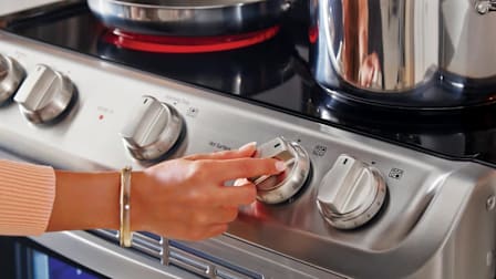 A woman turning a knob on a LG LDE4413ST Range