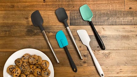 Five spatulas with a plate of cookies