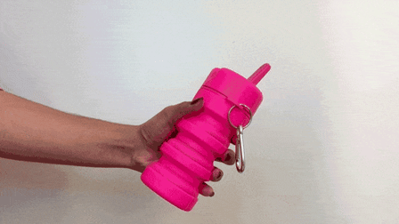 GIF of person squeezing a pink Tushy Portable Bidet