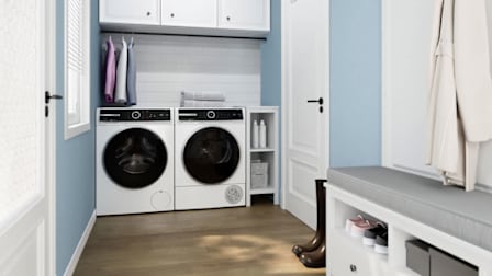 baby blue and white laundry room with white Bosch 500 Series WGB24600UC Washer and Bosch 500 Series WQB245B0UC Dryer