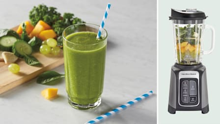 A green smoothie in a glass next to a Hamilton Beach 58600 smoothie with fruit and vegetables inside.