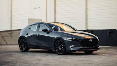 2026 Mazda3 in grey on concrete with white industrial building in background