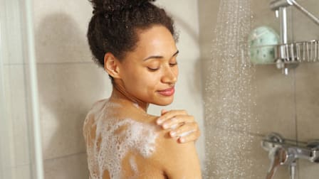 A woman in the shower washing her body.