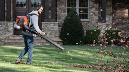 A man using a Husqvarna 360BT backpack leaf blower.