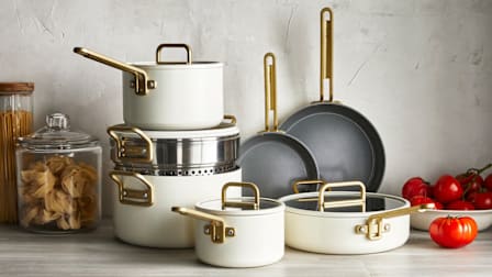 GreenPan Stanley Tucci Ceramic Nonstick cookware set on countertop wth dried pasta jars and bowl of tomatoes