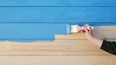 a person painting a wall blue