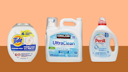 Tide Plus Hygienic Clean 10X, Kirkland Signature (Costco) UltraClean Free & Clear, and Persil Everyday Clean Free & Sensitive laundry detergents on orange and brown background