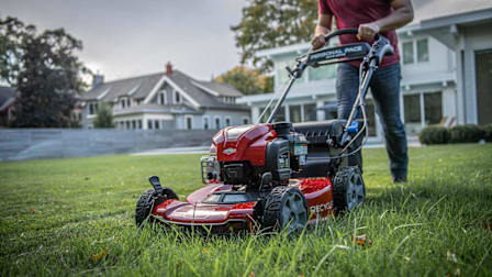 a person mowing a residential lawn with a Toro Personal Pace Recycler 21465 Gas Self-Propelled Mower