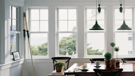 Andersen windows in dining room with table and oars leaning in corner