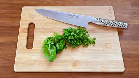 knife on Totally Bamboo Cutting Board with chopped basil
