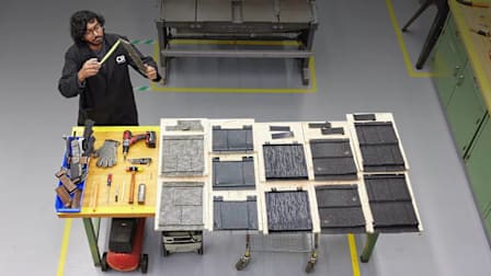 A CR Technician measuring several types of metal roofing shingles.