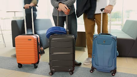 Three travelers standing with their carry-on luggage