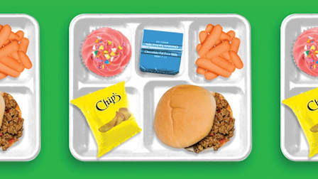 overhead view of photo illustrated food tray with cupcake, chocolate milk, carrots, chips, and sloppy joe on green background