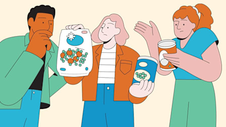 Three people examine and discuss frozen and canned packaged food items