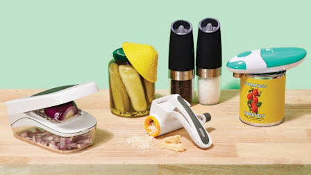 Clever kitchen tools on wooden surface with teal background