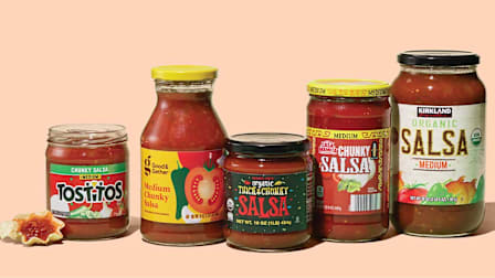 Multiple brands of salsas on a peach colored background.