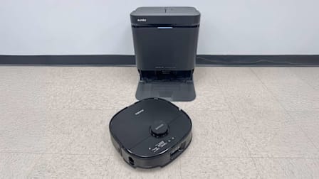 Eureka J15 Max Ultra base and vacuum on tan floor with grey wall