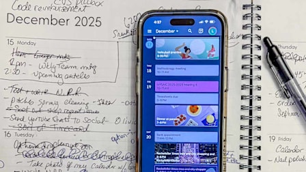 phone showing calendar events resting on paper calendar showing events
