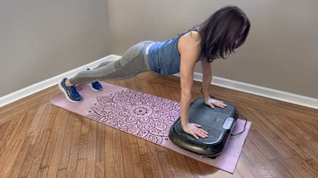 Consumer Reports editor doing a plank on the Lifepro Waver Vibration Plate Exercise Machine in her home.