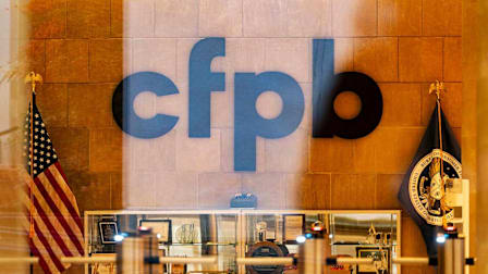 Looking through a glass door into the entrance of the CFPB headquarters in Washington, D.C.