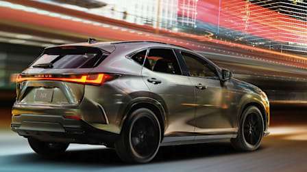 2027 Lexus NX 450h driving through brightly lit city