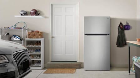 LG LRTLS2403S refrigerator in garage with door into house, corner of car, helmets, and shoe rack