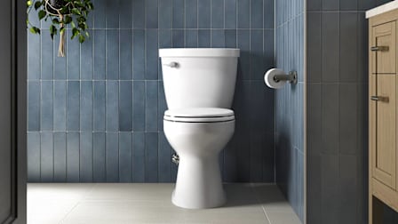 Kohler Cimarron Rev 360 K-31668 toilet seen in a blue-tiled bathroom.
