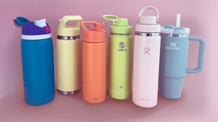 Owala FreeSip, Yeti Rambler, Simple Modern Summit, Takeya Actives, Hydro Flask Wide Mouth With Flex Chug Cap, and Stanley The Quencher H2.0 Flowstate Tumbler water bottles on pink background