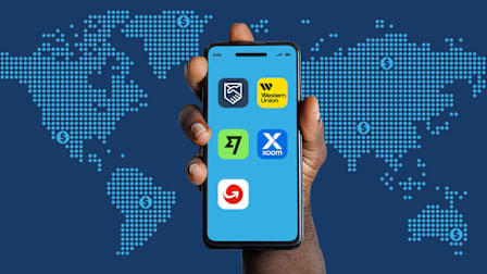 Hand with phone displaying the icons of tested remittance apps.